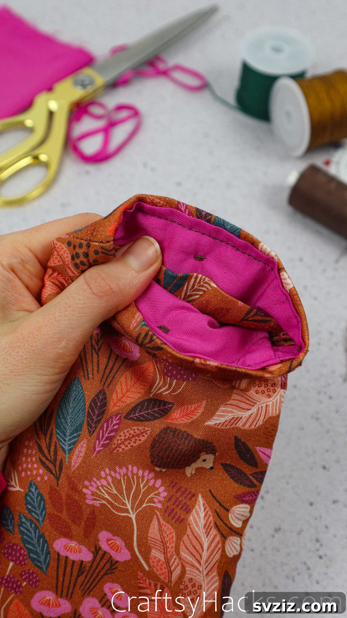 A second button sewn onto the opposite side of the fabric phone case, mirroring the first for a balanced closure.