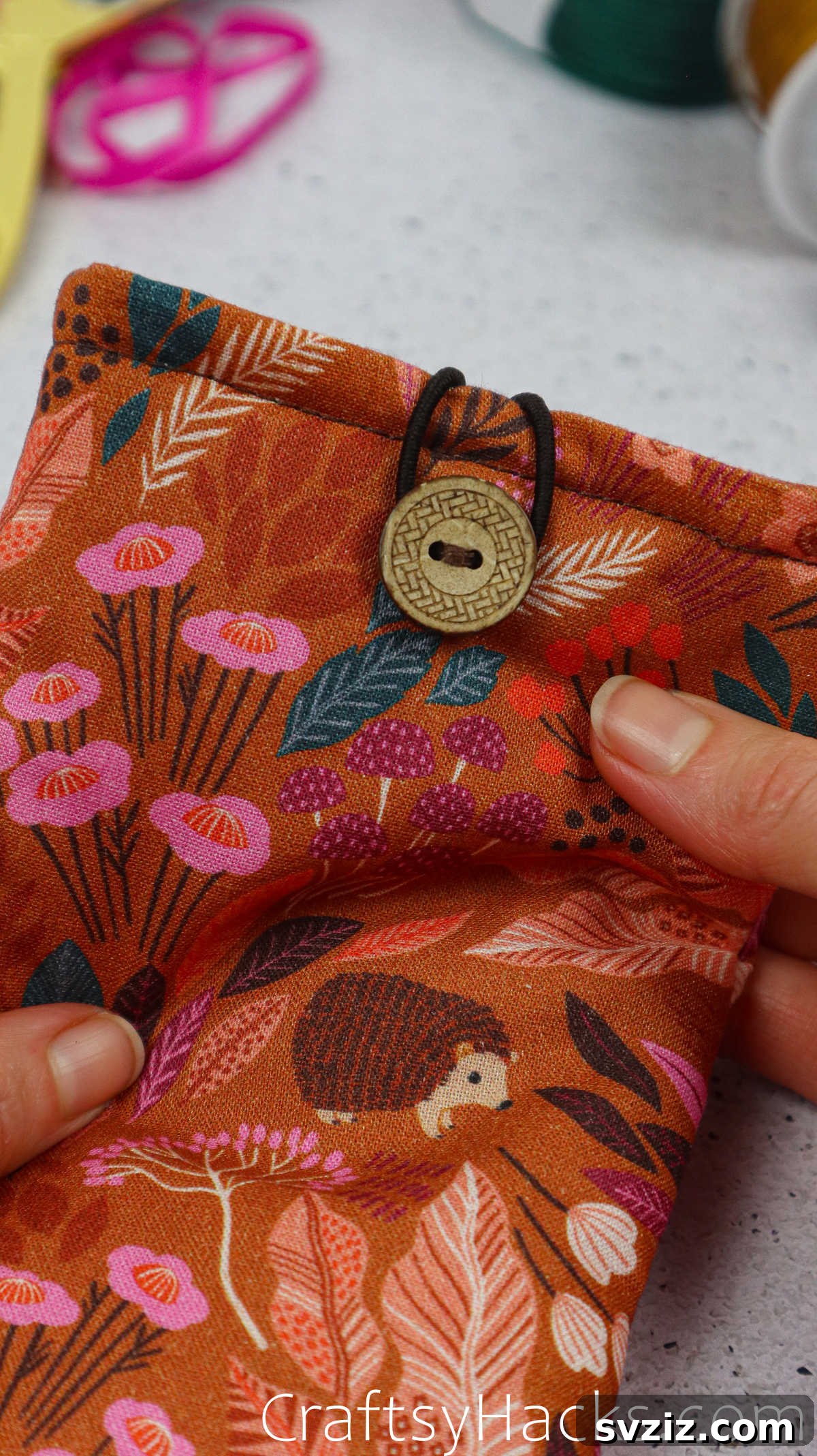 The finished fabric phone case with the elastic closure securely fastened around both buttons.