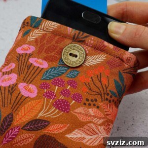 A handmade fabric phone case with a button closure, showcasing a cute design, perfect for protecting your phone.