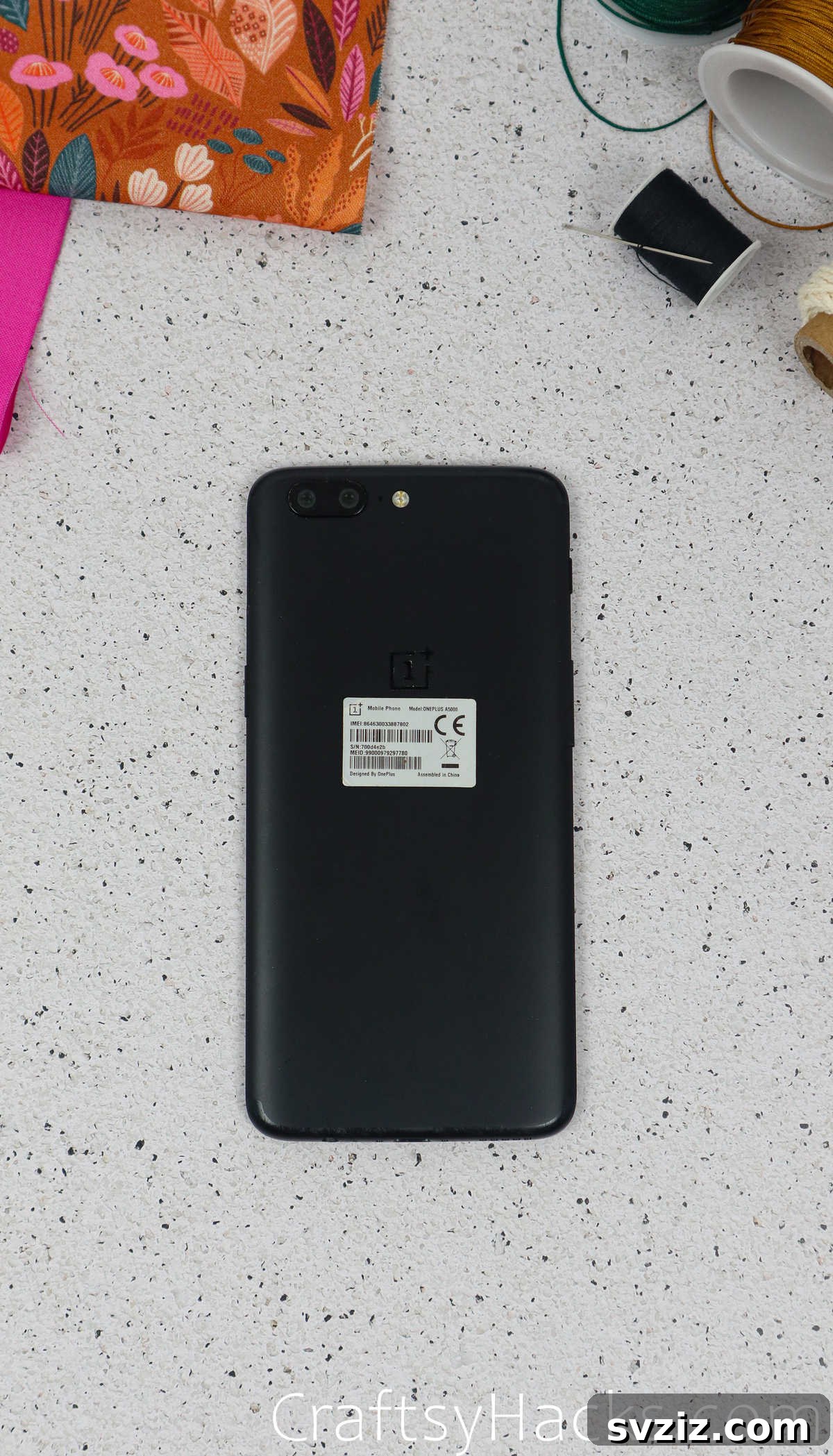 A smartphone being measured with a tape measure, emphasizing the importance of accurate dimensions for the DIY phone case.