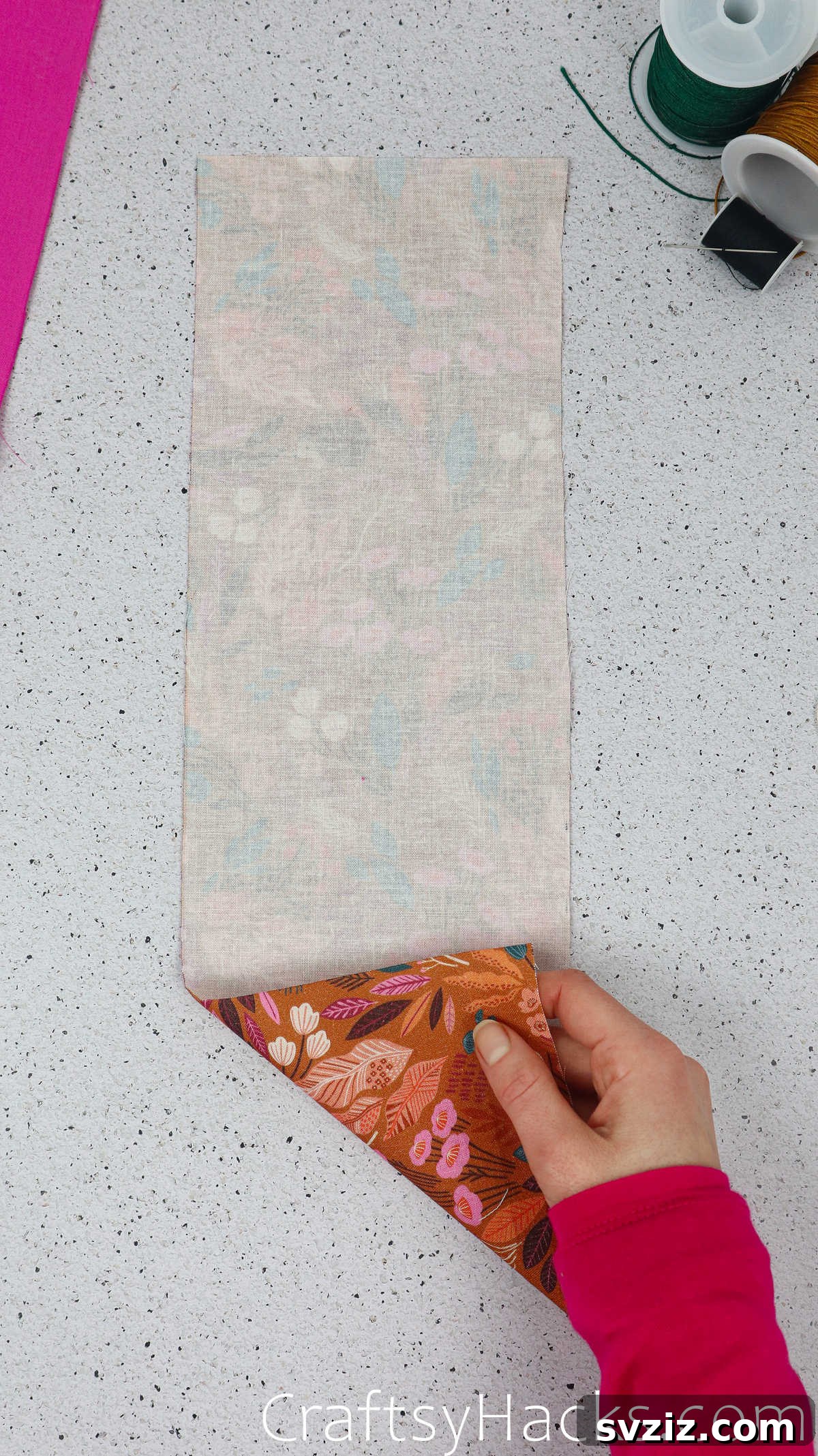 A patterned piece of cotton fabric laid flat, ready for the wadding layer in the phone case construction process.