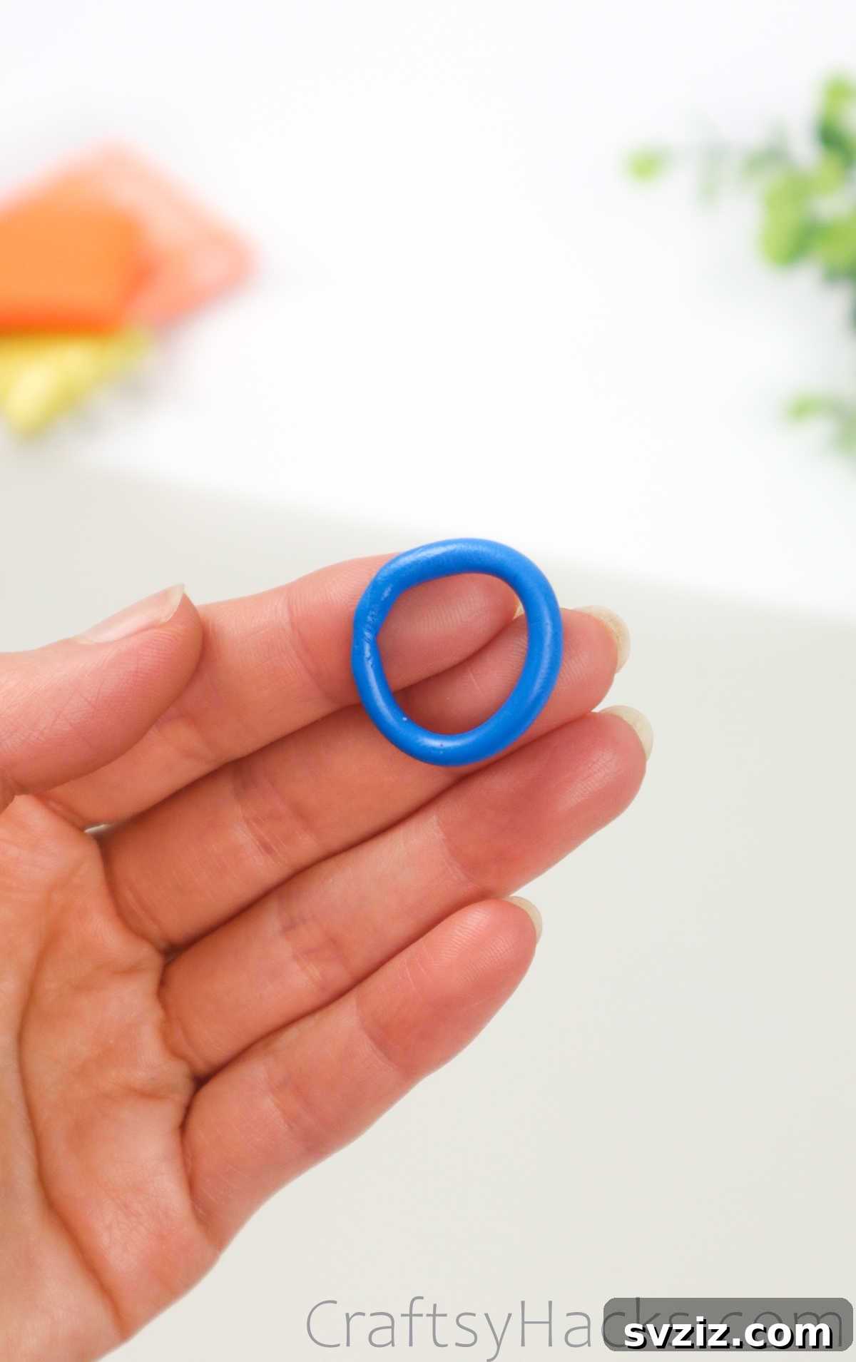 Crafting Your Own Clay Rings Effortlessly 12 A hand presenting a finished blue polymer clay ring, highlighting its smooth, continuous band