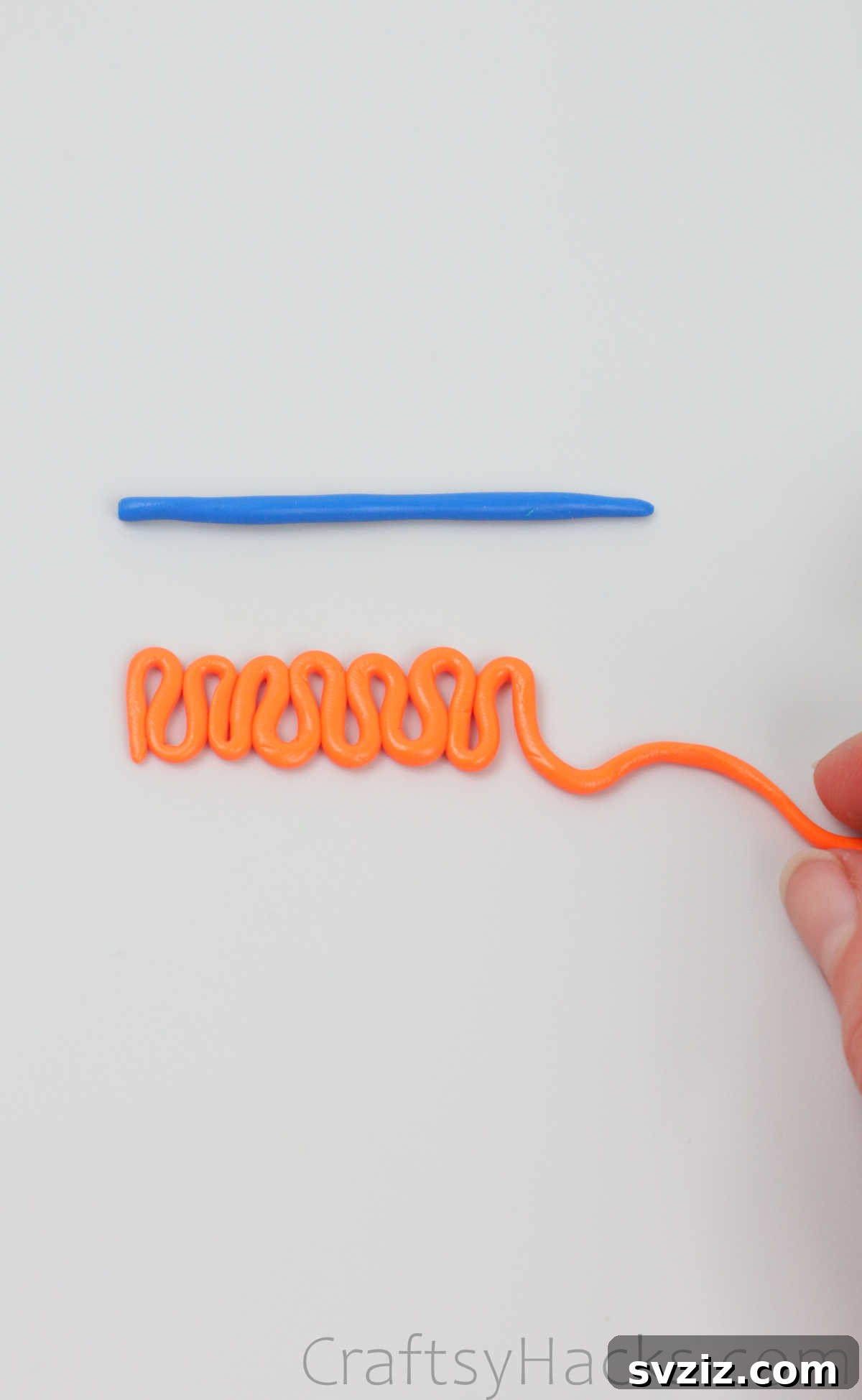 Crafting Your Own Clay Rings Effortlessly 14 Orange polymer clay being shaped into a delightful zigzag or squiggly pattern