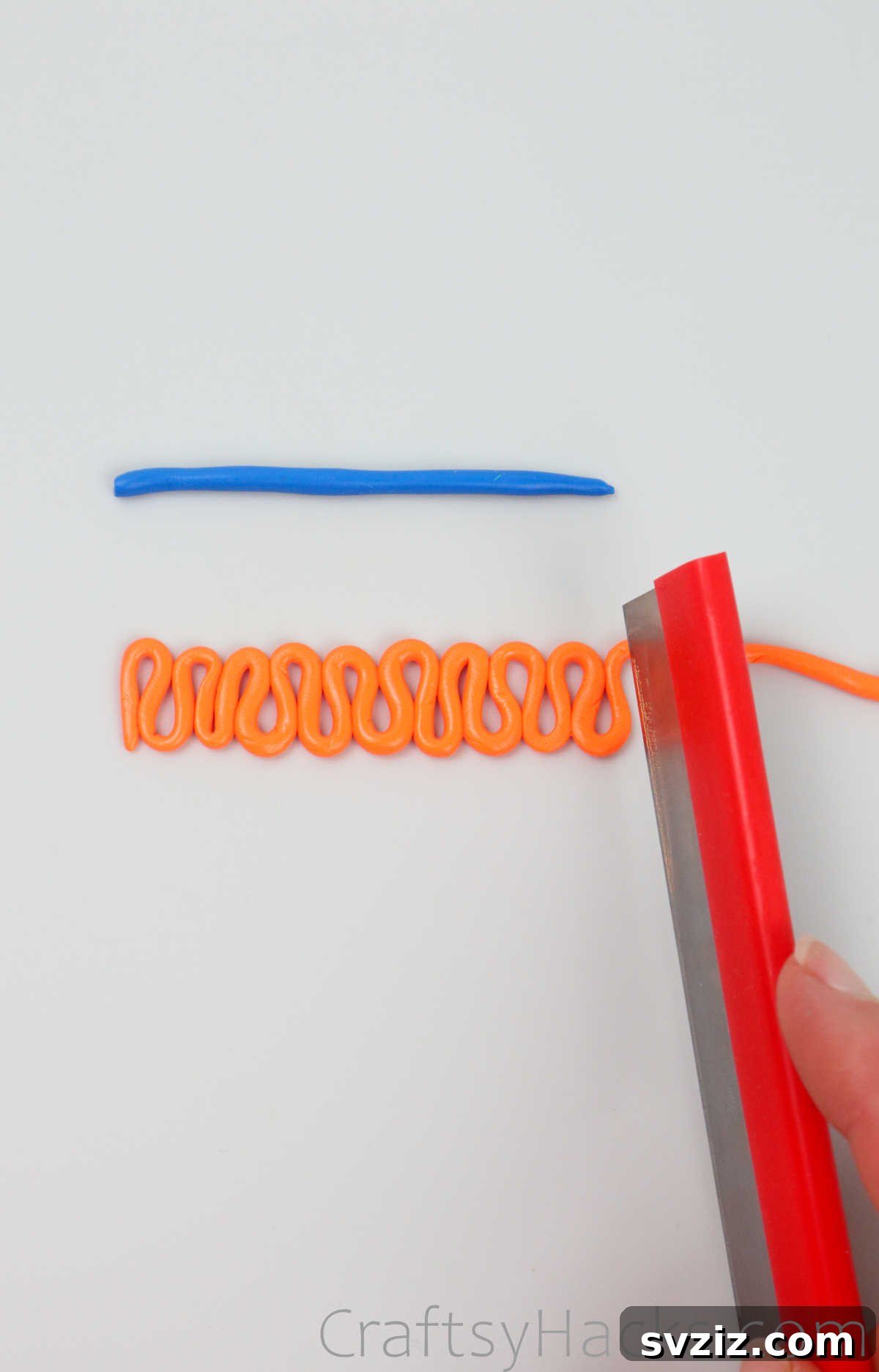 Crafting Your Own Clay Rings Effortlessly 15 A craft knife carefully cutting the ends of a squiggly orange polymer clay strip