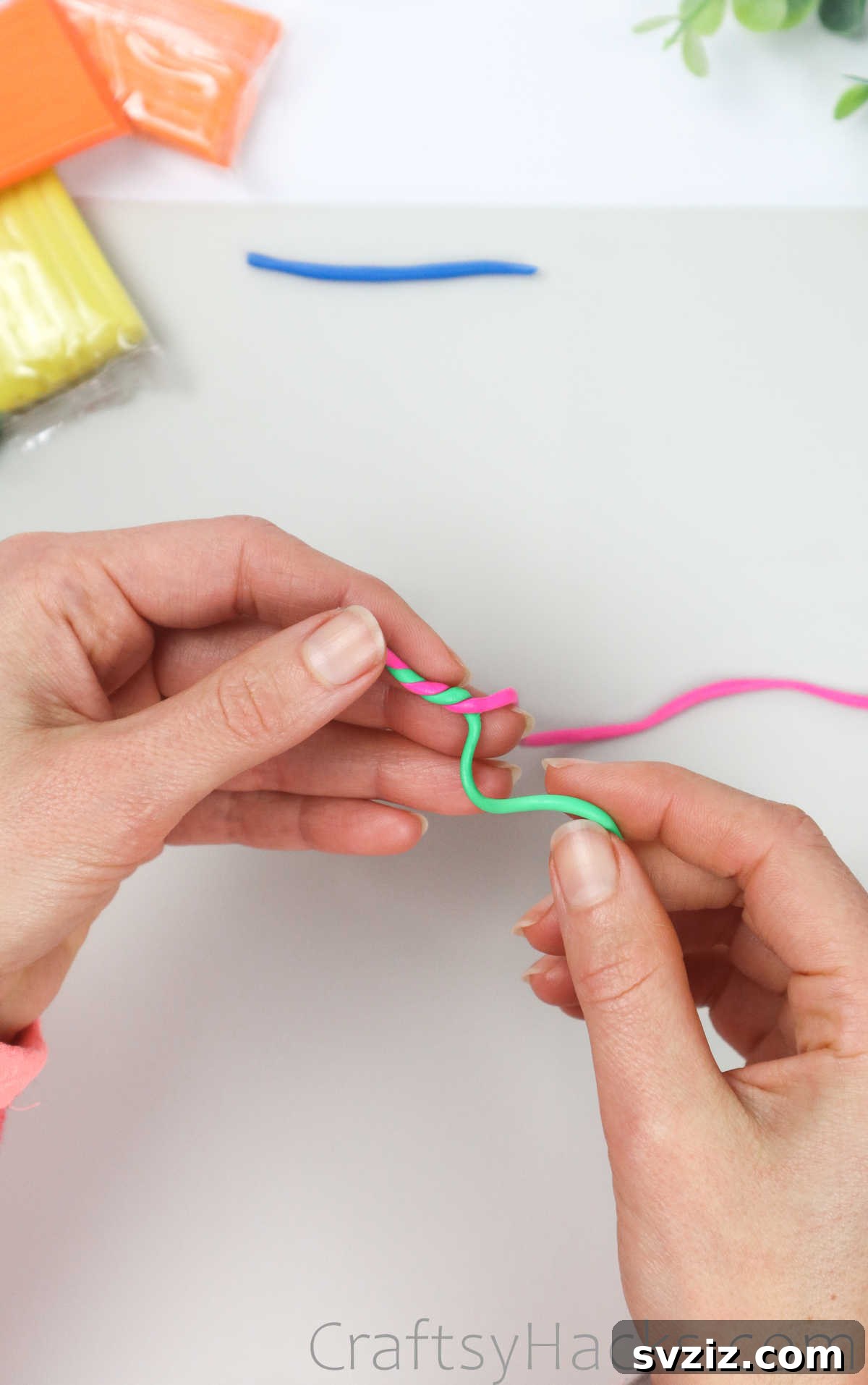 Crafting Your Own Clay Rings Effortlessly 18 Pink and green polymer clay strands being twisted together to form a striped pattern