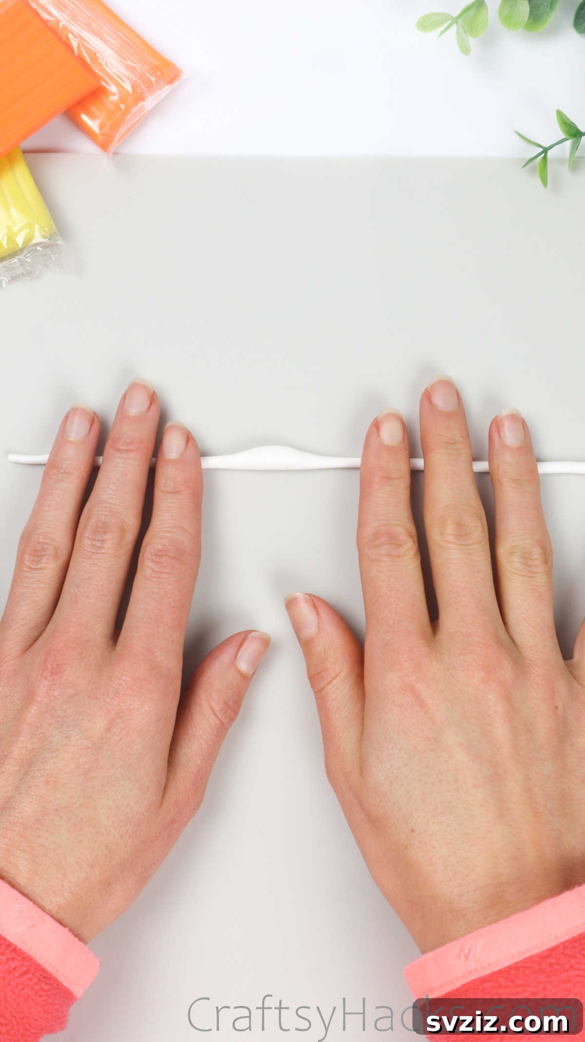 Crafting Your Own Clay Rings Effortlessly 21 A hand rolling white polymer clay, creating a long strand with a deliberate bump in the middle