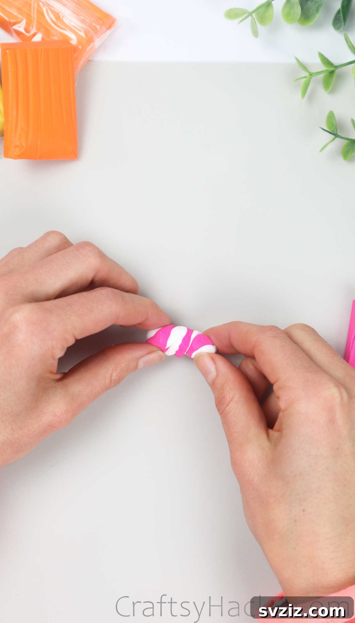 Crafting Your Own Clay Rings Effortlessly 27 A hand gently blending pink and white polymer clay together to create a marbled pattern