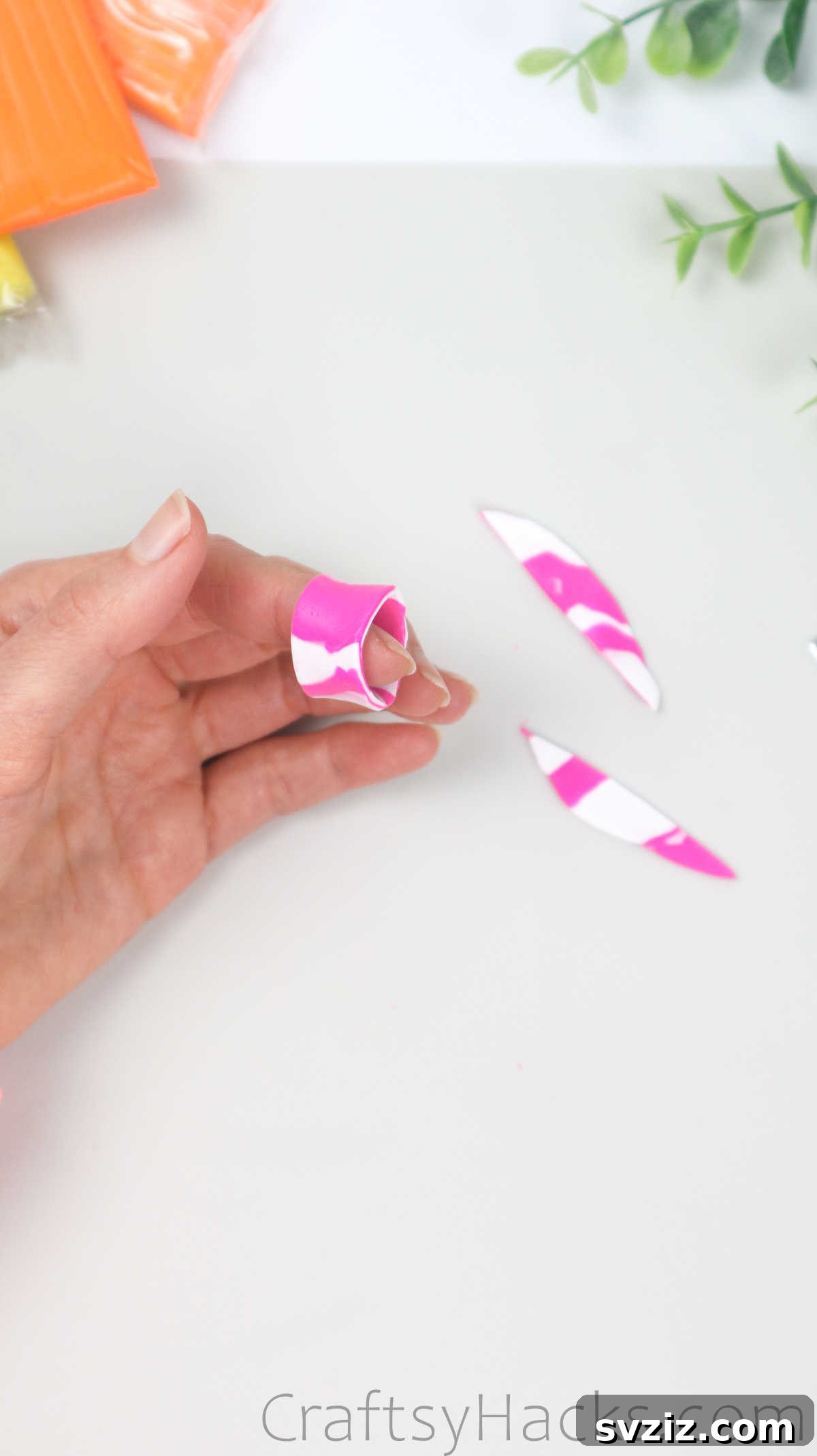 Crafting Your Own Clay Rings Effortlessly 31 A hand wrapping a marbled polymer clay strip around a finger to form an asymmetric ring