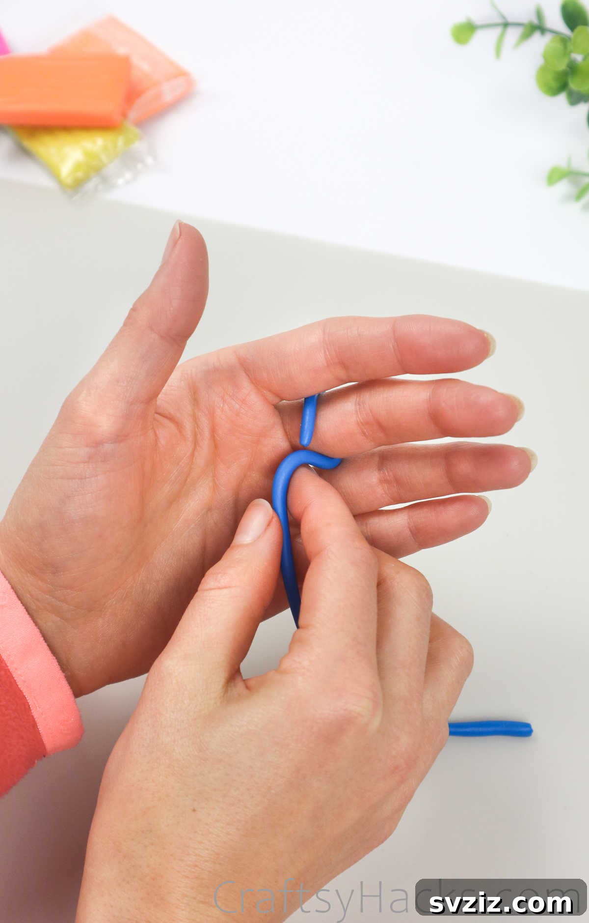 Crafting Your Own Clay Rings Effortlessly 8 A thin strand of blue polymer clay being wrapped around a finger to measure ring size