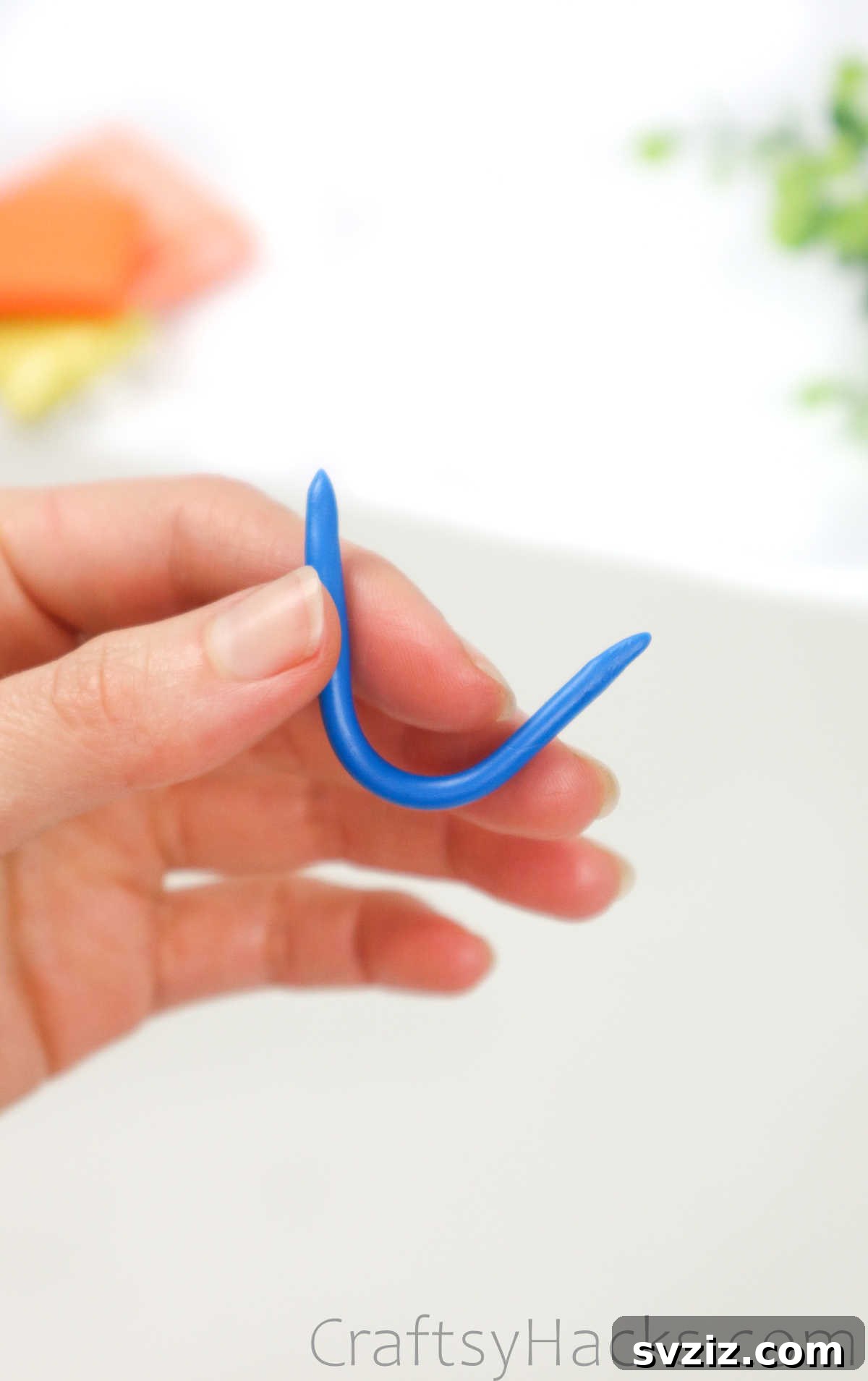 Crafting Your Own Clay Rings Effortlessly 10 A hand holding a neatly cut segment of blue polymer clay, ready to be formed into a ring