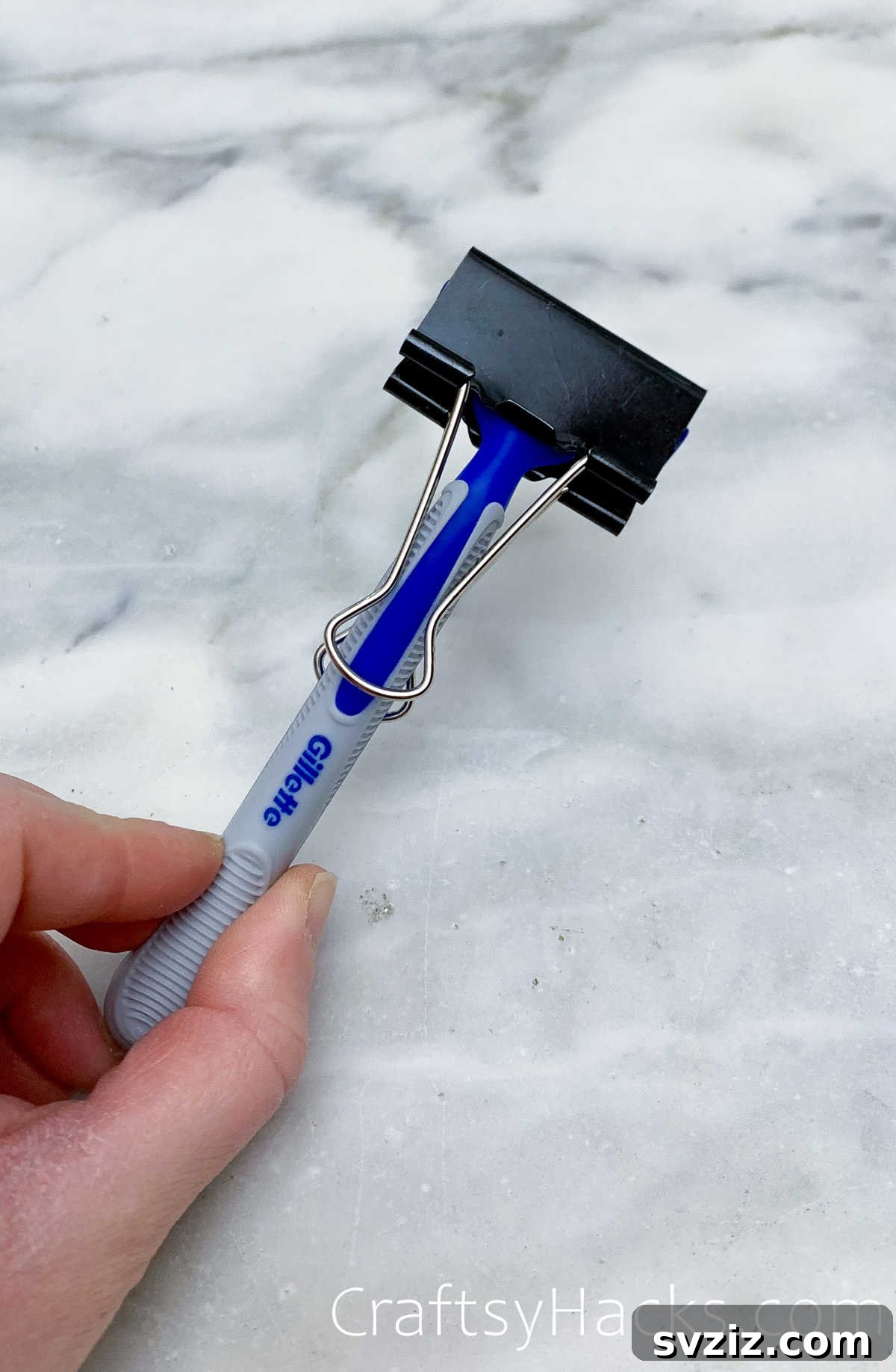 Binder clip protecting a razor blade for safe travel