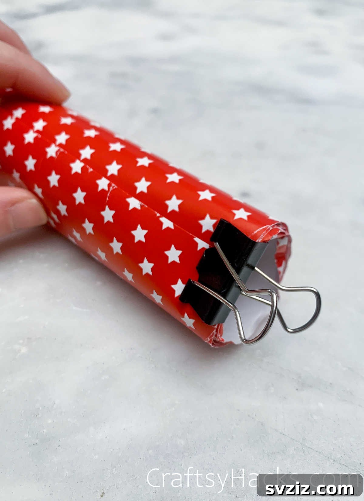 Binder clips securing rolls of wrapping paper to prevent unrolling