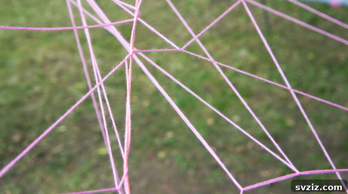 Kids playing a spider web team building game with yarn or rope
