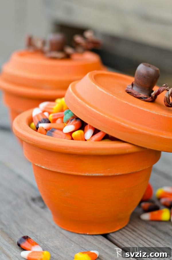 Whimsical DIY pumpkin terracotta pots, painted orange with a green stem, creating charming fall decor or candy dishes.