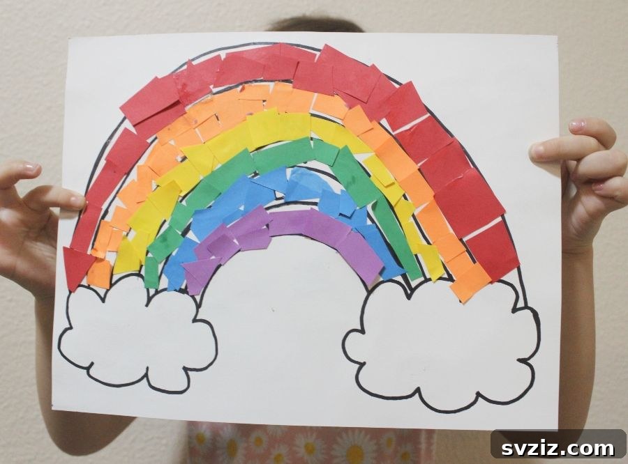 Easy construction paper rainbow craft, where torn colorful paper pieces are glued onto an arc, practicing color recognition and fine motor skills.