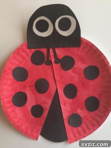 Simple ladybug paper plate craft with red paint and black spots, ideal for toddlers to practice cutting and gluing skills.