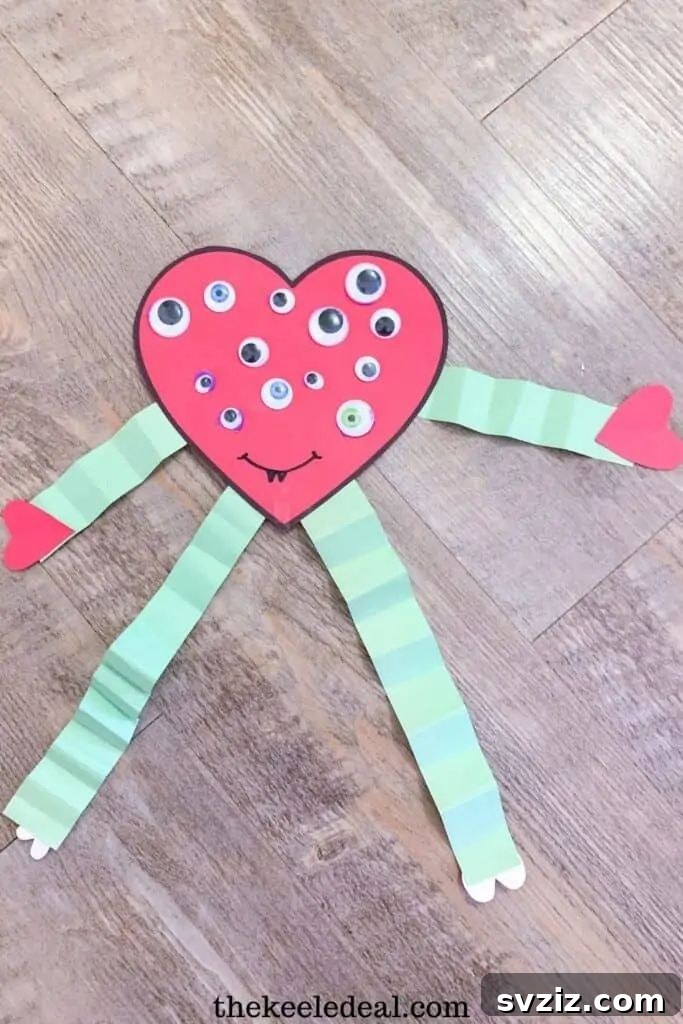 Adorable climbing heart monster Valentine's Day craft for kids, made with paper hearts and accordion-folded limbs, perfect for gifting.