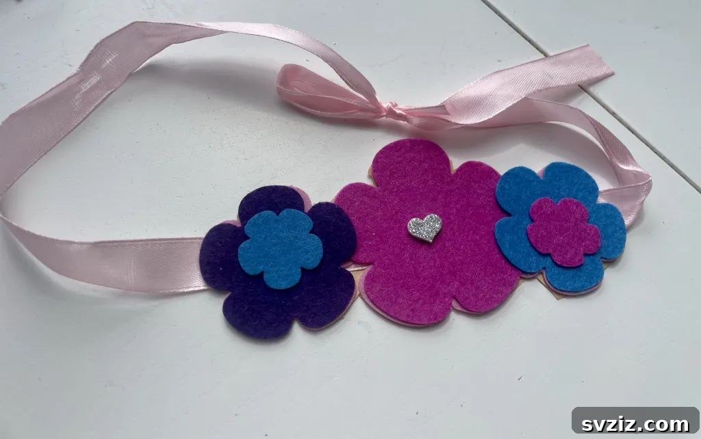 Easy DIY flower ribbon hairband for kids, made with felt flowers and a fabric ribbon, perfect for dress-up and imaginative play.