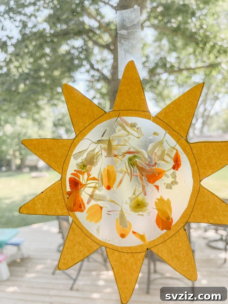 Bright sun suncatcher craft for kids, made with colorful tissue paper on contact paper, perfect for decorating windows and bringing cheer.