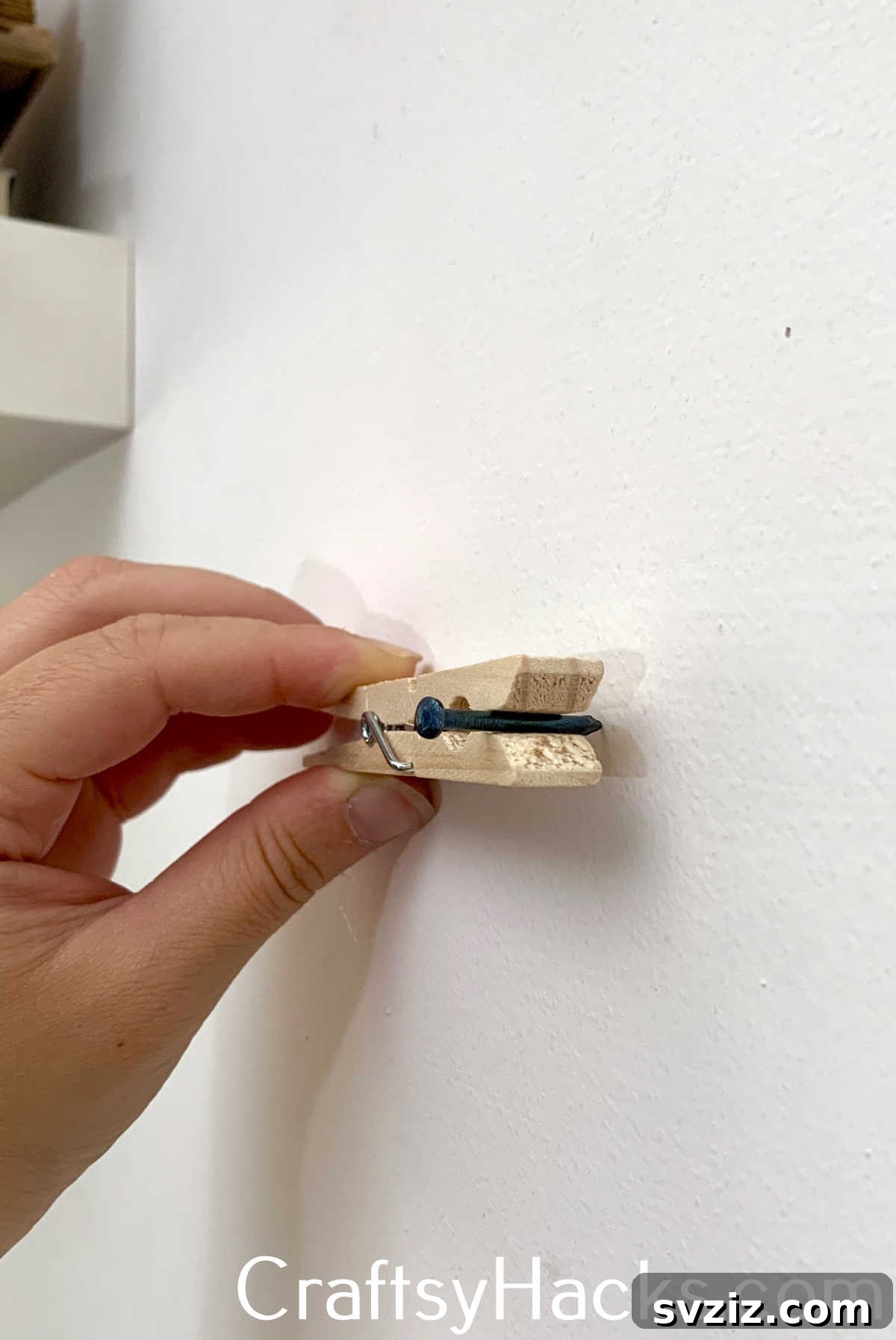 A simple clothespin can safely hold a nail in place while hammering, protecting your fingers from accidental strikes and improving precision for DIY projects.