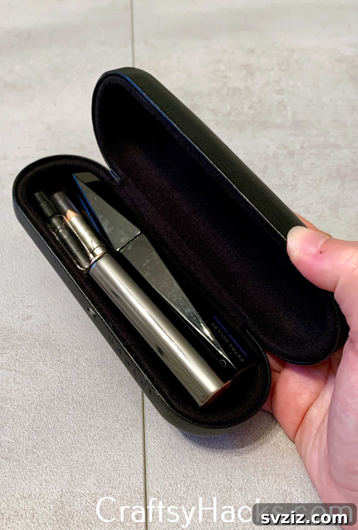 An empty glasses case is a practical and protective way to organize and store long, skinny makeup items like mascara, eyeliners, and brushes while traveling, preventing loss and damage.