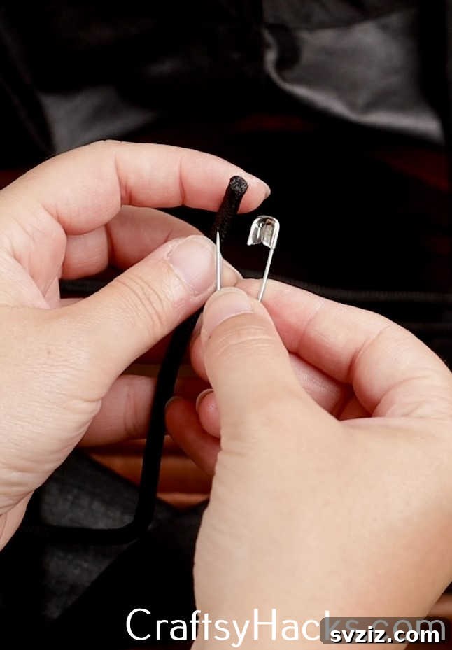 A simple safety pin can be used as a clever tool to easily fix and re-lace tangled or lost drawstrings in hoodies, pants, or shoes, saving time and frustration.