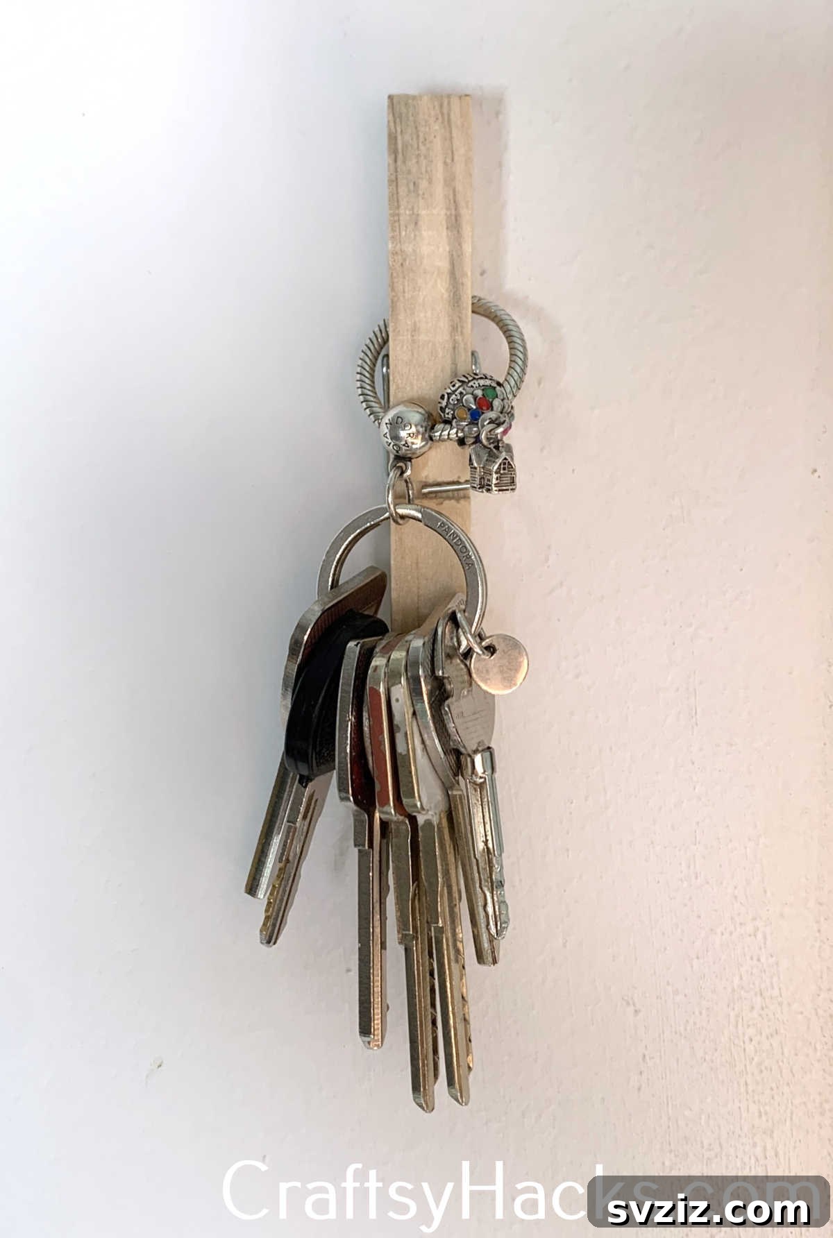 Create a convenient, minimalist key hook using a clothespin and strong double-sided tape, perfect for keeping keys organized and accessible near entryways.