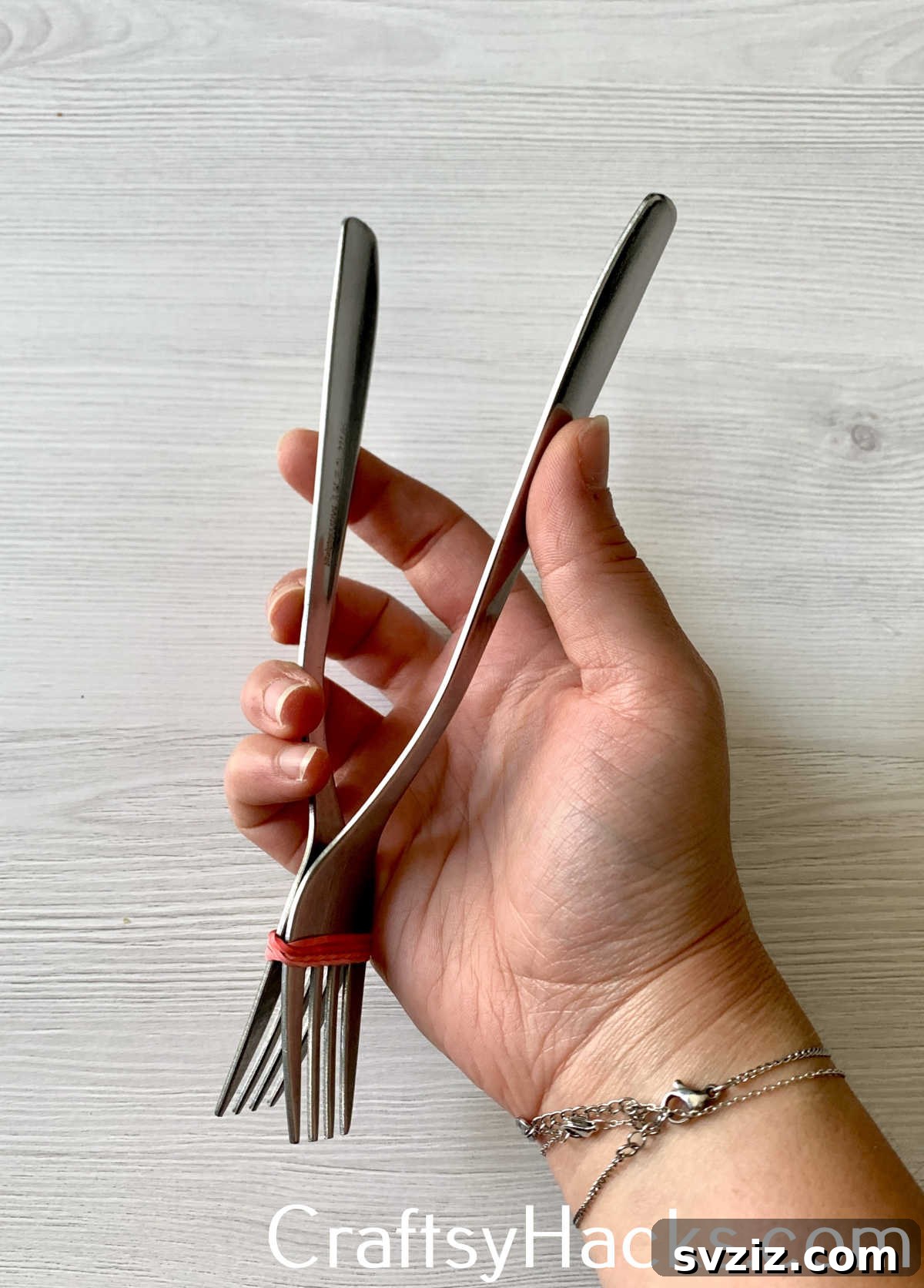 Fashion quick, temporary tongs by tying two forks together with a rubber band, a resourceful cooking hack for grilling, tossing salads, or handling food when proper tongs are unavailable.