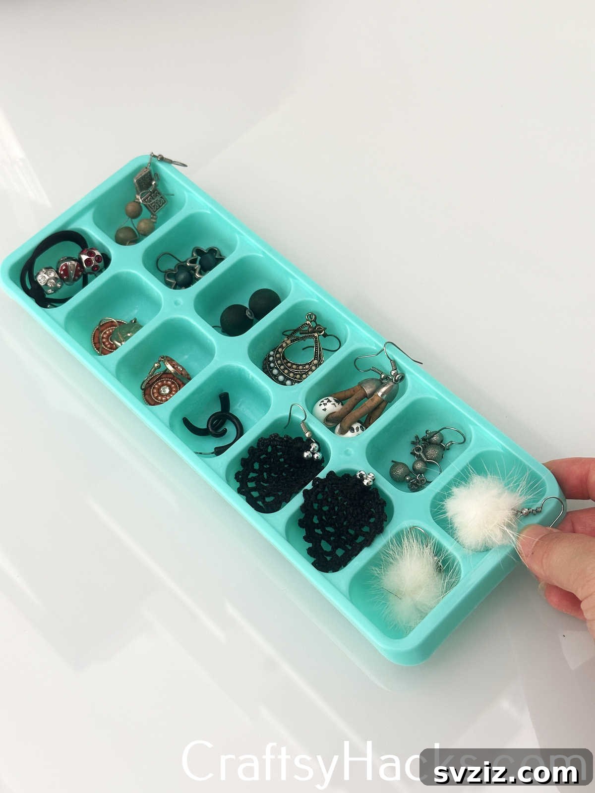 Organize and store pairs of earrings neatly in an ice cube tray, preventing tangles and making them easy to find.
