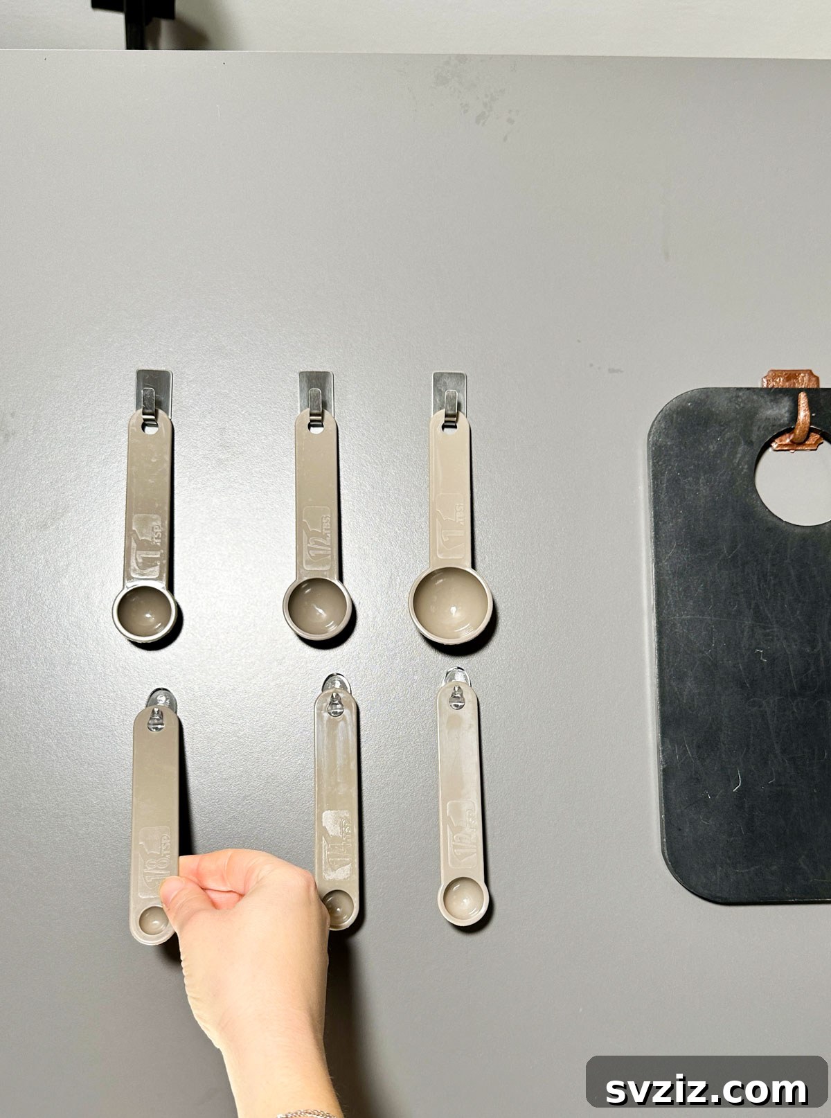21 Clever Ways to Declutter Your Home Without Spending a Fortune 15 Use Command Hooks to Hang Measuring Spoons