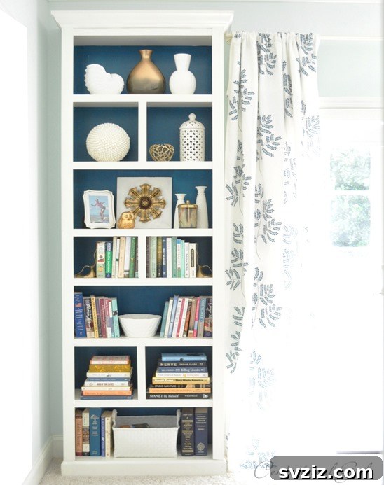 Smart Space Solutions for Couples Bedrooms 20 Tall IKEA Billy Bookcase configured as a floor-to-ceiling display and storage unit, maximizing vertical space in a small bedroom and adding a splash of color to the back panel.