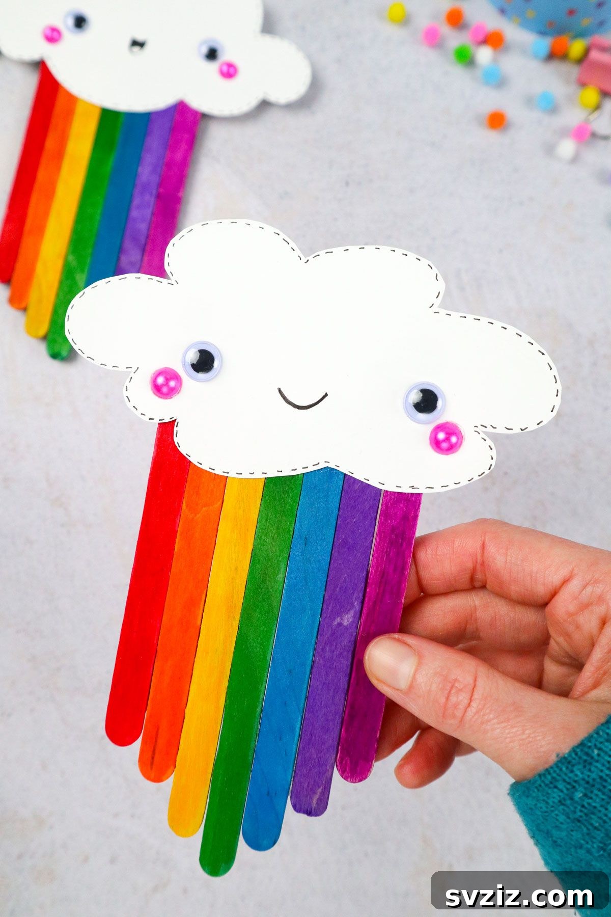 Popsicle Stick Rainbow Extravaganza 2 Rainbow Popsicle Stick Craft, featuring a completed craft with a smiling cloud and colorful sticks.