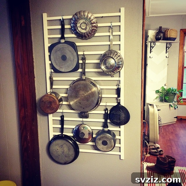 Hang a pots and pans rack, made from an old crib rail, to save cabinet space and keep essential cookware easily accessible in a small kitchen.