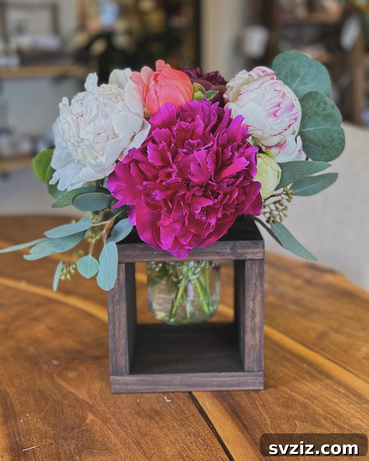 27 Elegant Round Table Wedding Centerpiece Inspirations 12 Rustic wedding centerpiece featuring a small floral arrangement in a natural wooden box holder.