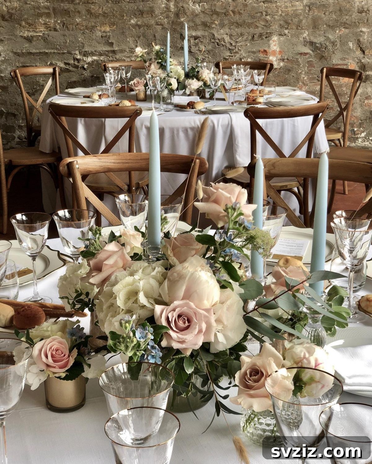 27 Elegant Round Table Wedding Centerpiece Inspirations 14 Blush-toned floral arrangement centerpiece with elegant dove-gray pillar candles.