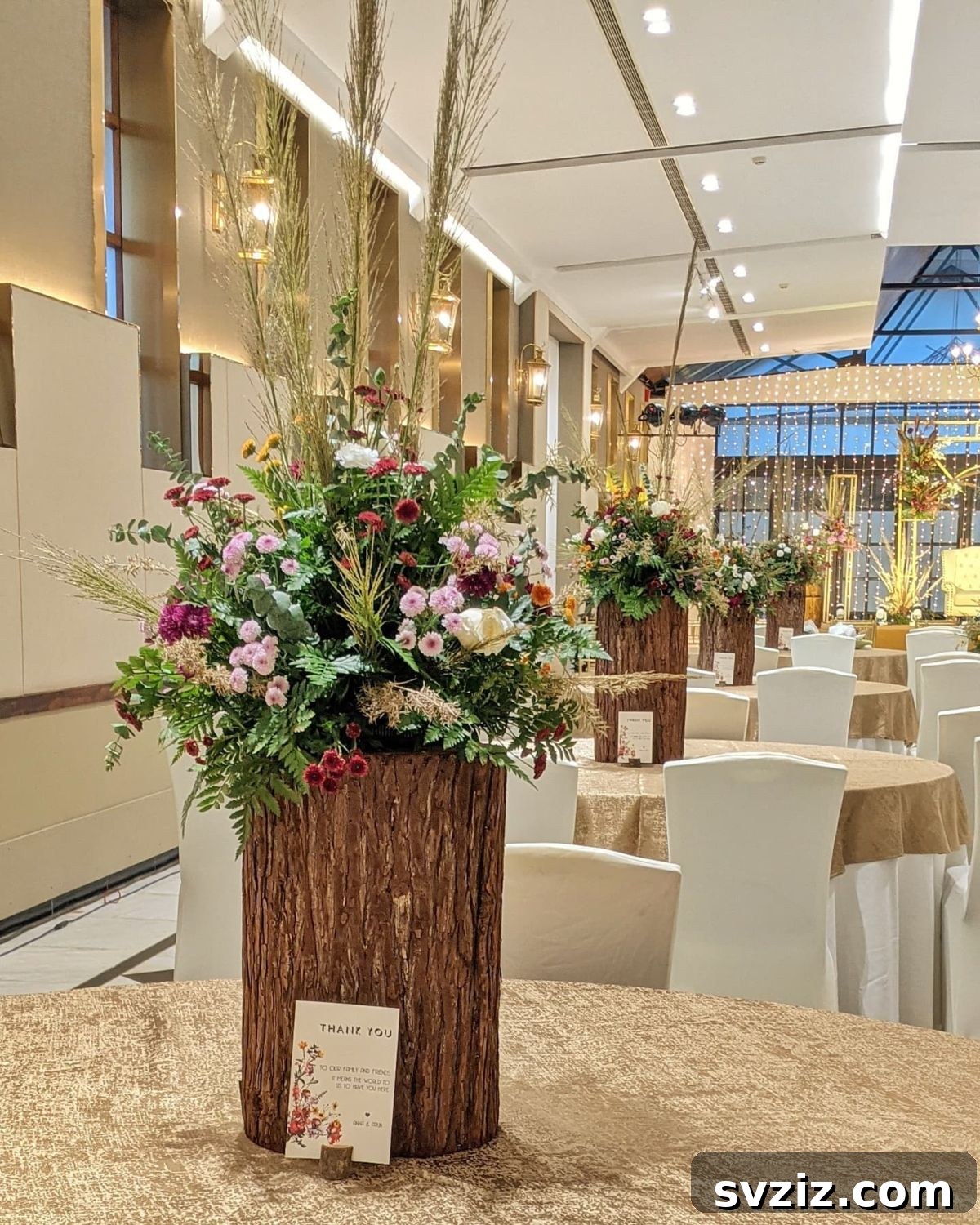 27 Elegant Round Table Wedding Centerpiece Inspirations 18 Tall woodland-themed wedding centerpiece with wood bark holders and vibrant floral arrangements.