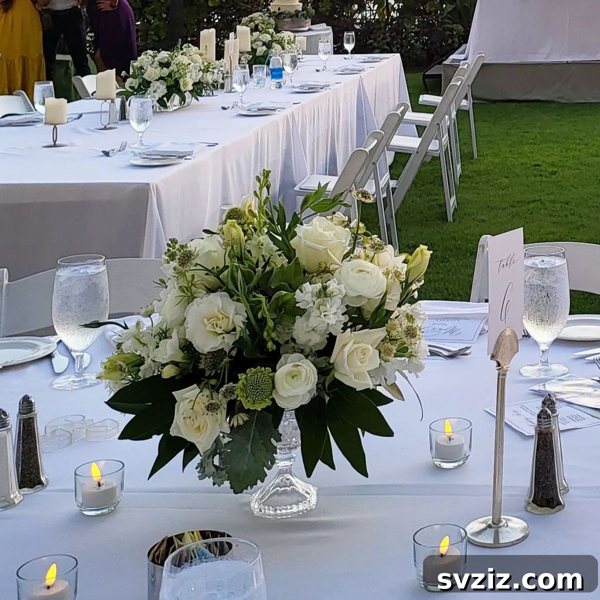 27 Elegant Round Table Wedding Centerpiece Inspirations 23 Classic white-themed wedding floral display with roses, calla lilies, and hydrangeas.
