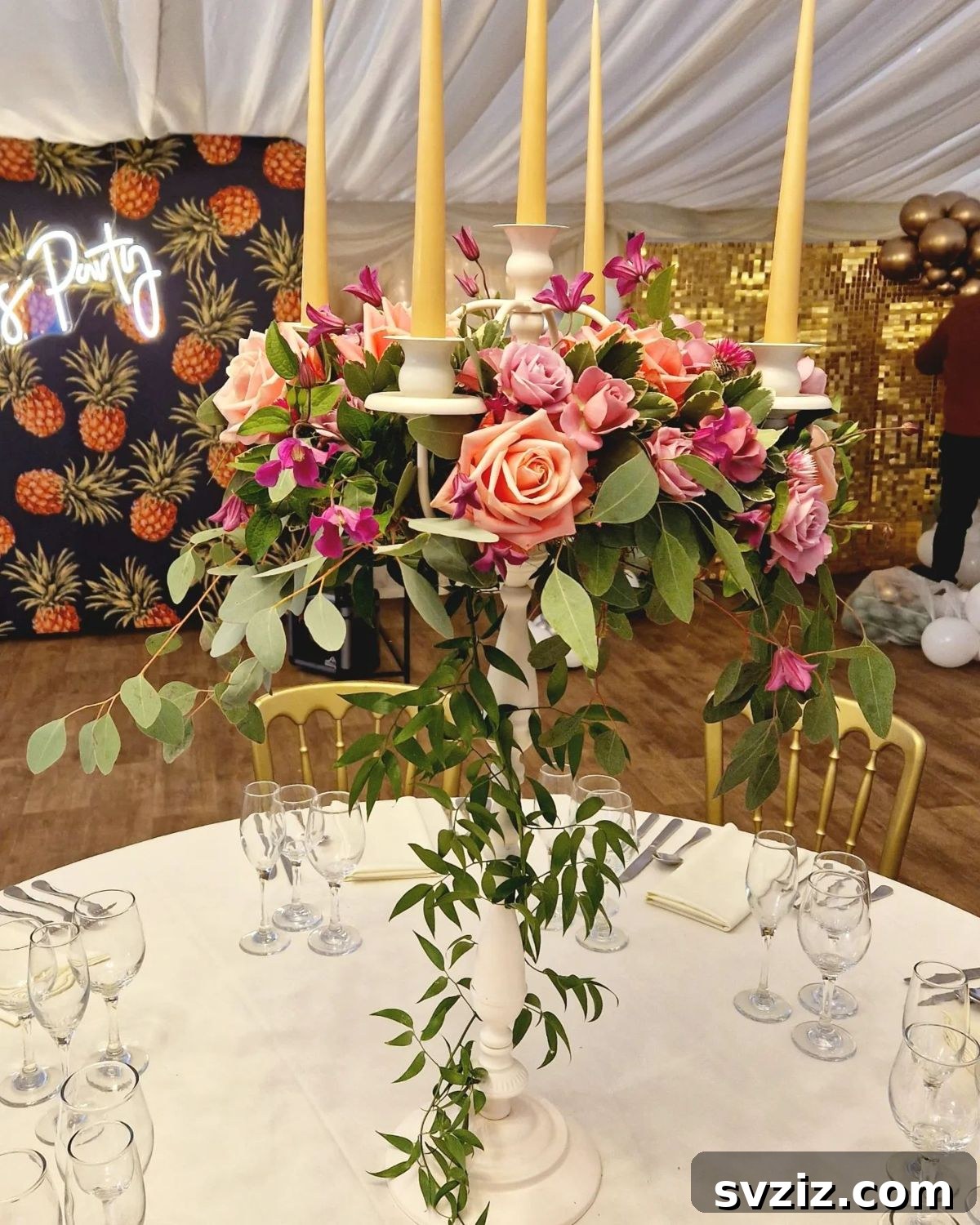 27 Elegant Round Table Wedding Centerpiece Inspirations 25 Ornate candelabra wedding centerpiece featuring roses, clematis, eucalyptus, and tall golden candles.