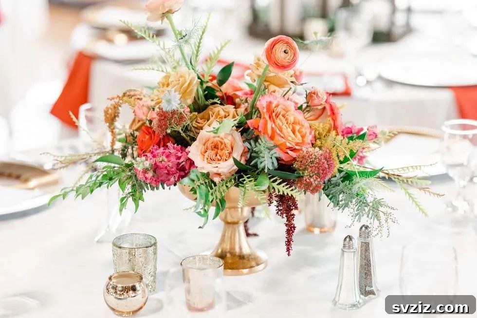 27 Elegant Round Table Wedding Centerpiece Inspirations 28 Charming wedding centerpiece with pink and orange florals in a low rose gold vase.