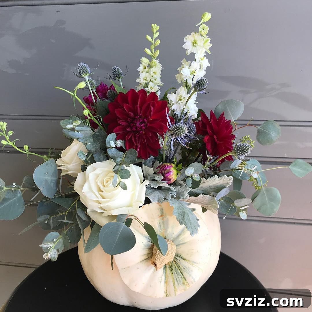 27 Elegant Round Table Wedding Centerpiece Inspirations 4 Fall wedding centerpiece with vibrant flowers and a decorative pumpkin.