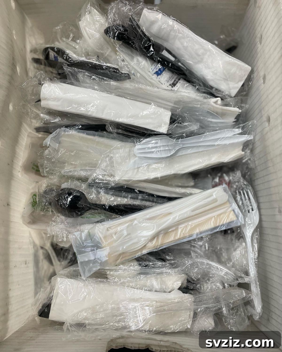 Drawer full of plastic utensils and sauce packets from takeout