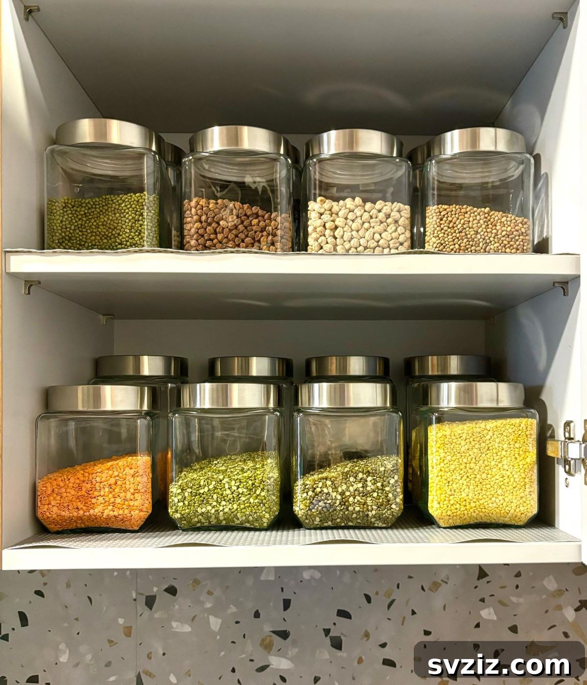 21 Genius Tricks to Tame Kitchen Clutter 17 Pantry shelves with clear glass jars filled with various dry foods