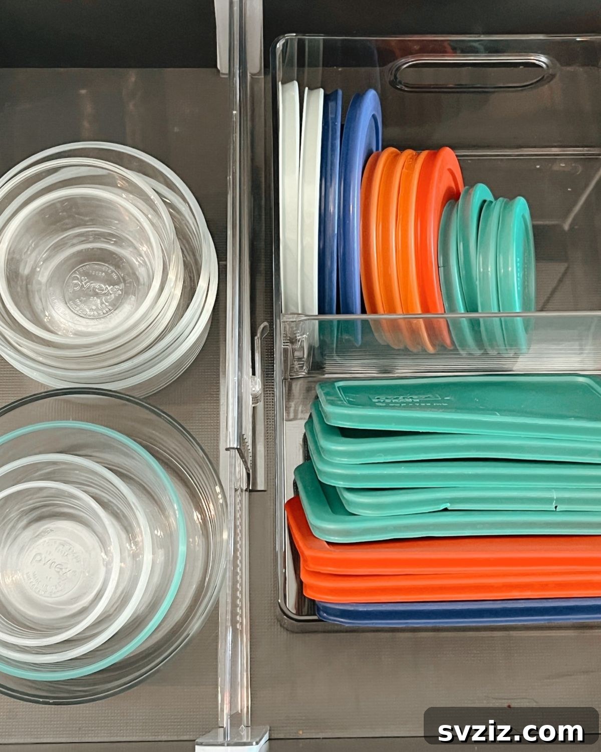 A drawer organized with a clear basket containing various Tupperware lids, neatly stacked for easy access.
