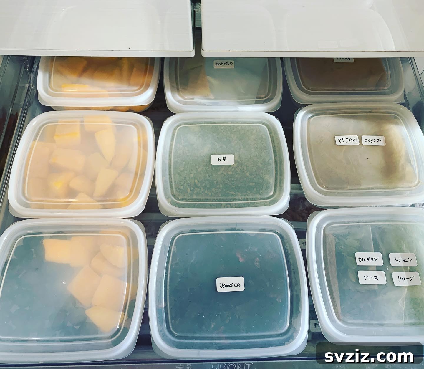 A well-organized freezer drawer featuring clear tubs separating various frozen food items for easy access.