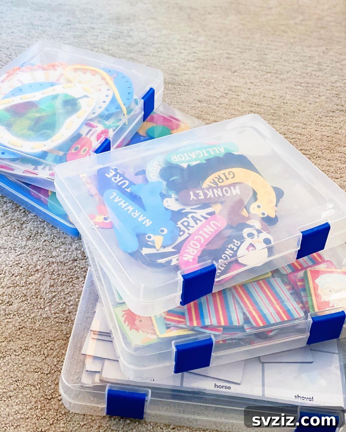 Clear document cases neatly stacked, holding children's artwork and small toys, offering compact and protected storage.