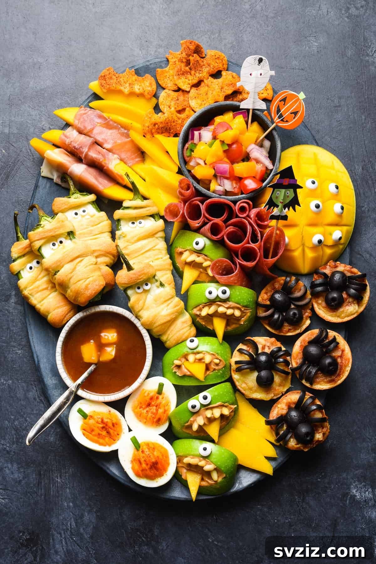 31 Terrifying Halloween Bash Concepts 9 Platter of Halloween snacks including spider pizzas and mummy jalapenos