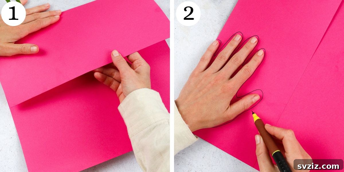 Flamingo Handprint Delight 4 An image showing a child's hand being traced onto pink construction paper, with the pinky finger aligned to the folded edge, to create the flamingo body.
