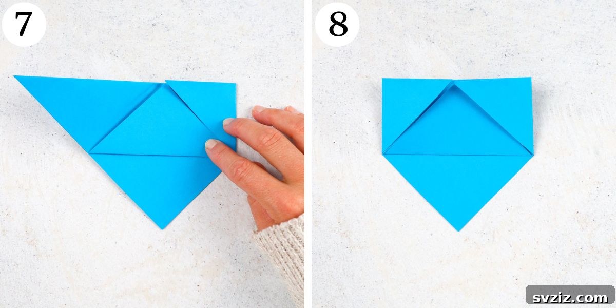 Fold the right corner in to meet the top edge and tuck, then repeat with the left side to create the bookmark shape.