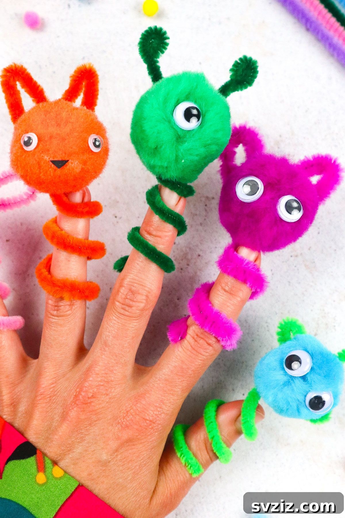 Adorable Pipe Cleaner Puppets in various colors standing on a wooden surface.