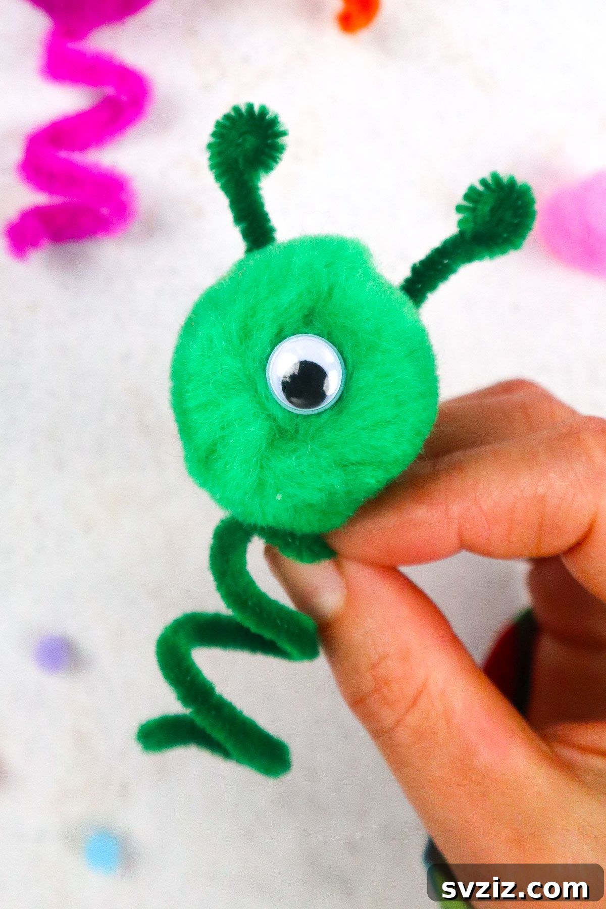 A finished, cheerful pipe cleaner puppet with bright colors and googly eyes.